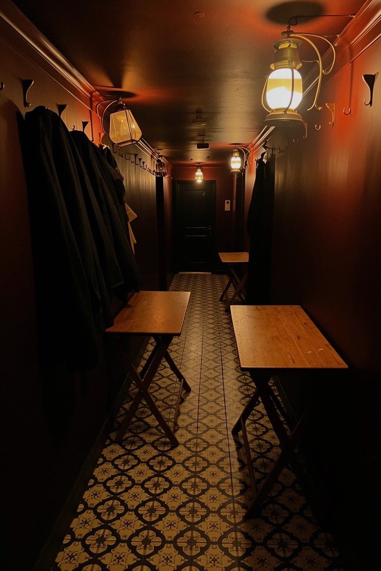 Narrow red hallway with wall hooks holding dark coats and small wooden folding tables below