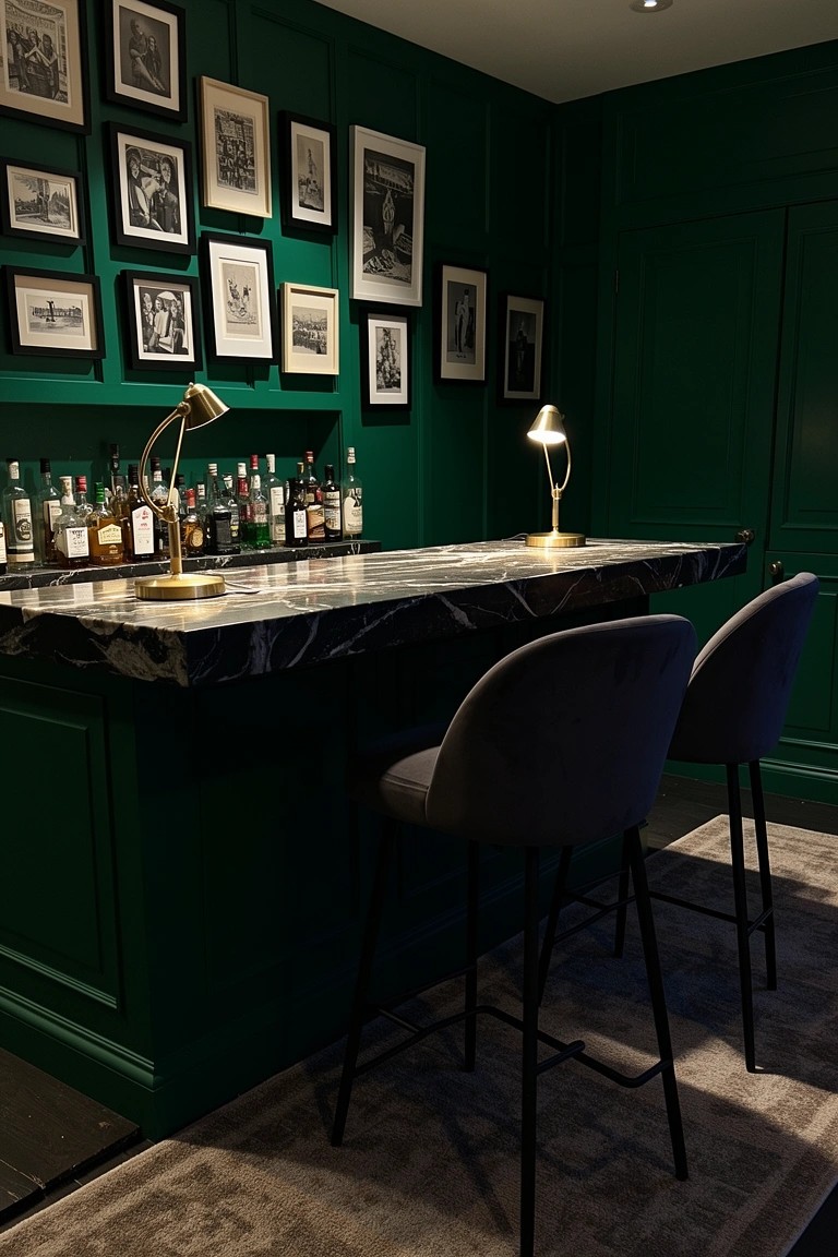 Emerald green paneled room with black marble bar top, brass lamps, gray stools, and bottle shelf lined by black-and-white photos