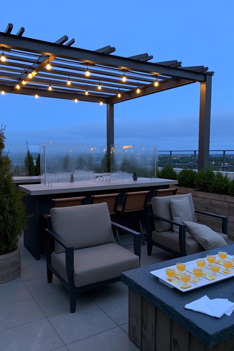 Rooftop bar setup under wooden pergola strung with lights, long counter with stools, lounge chairs, fire table, and platter of drinks