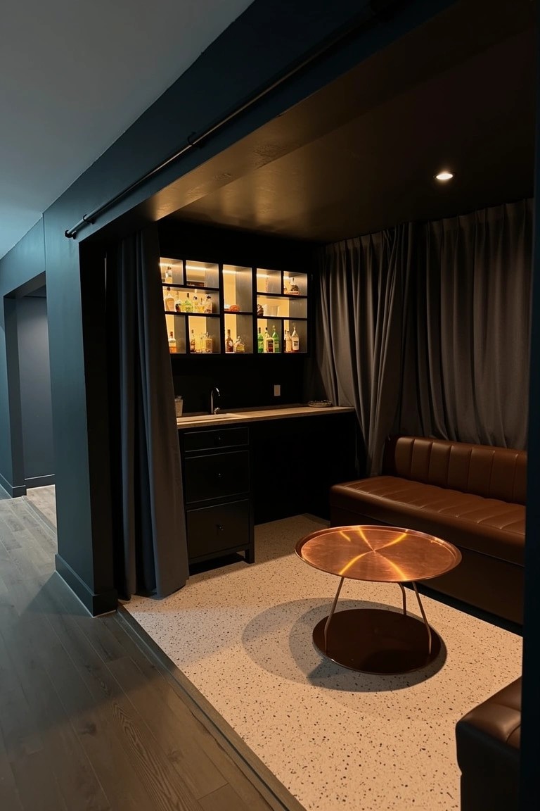 Moody enclosed bar nook in basement with backlit liquor shelves, sink counter, leather couch, and copper table