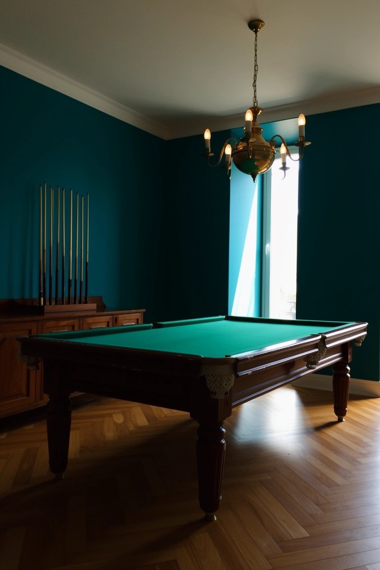 Wooden billiards table in a teal-walled room with cue rack, chandelier, and parquet floor