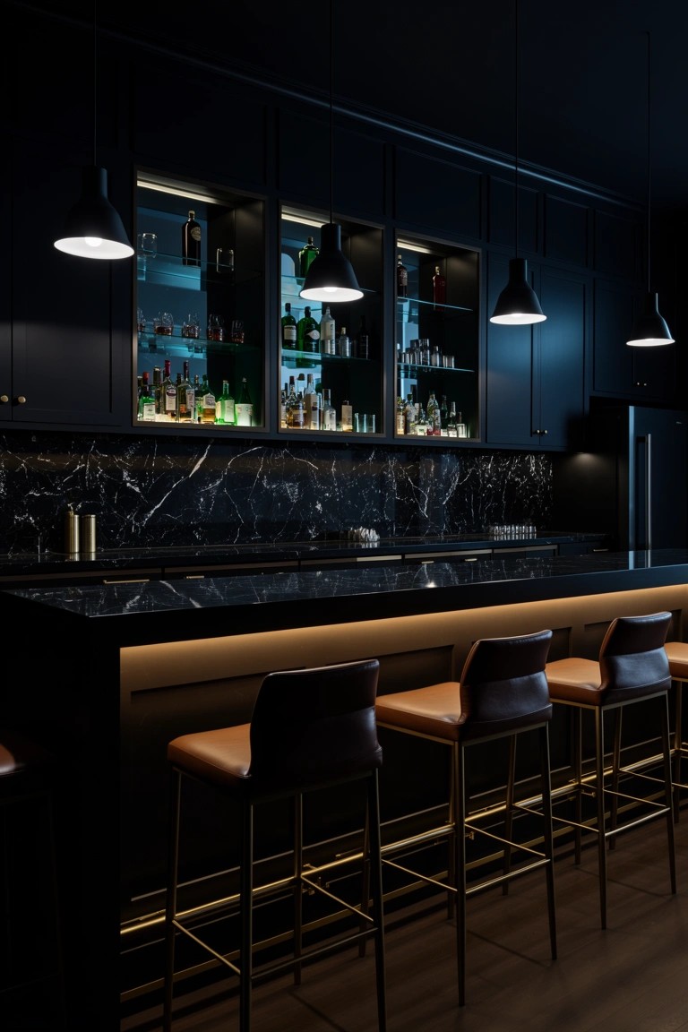 Sleek home speakeasy bar featuring black marble countertop with underlighting, dark cabinets, backlit glass shelves stocked with liquor bottles, and leather bar stools.