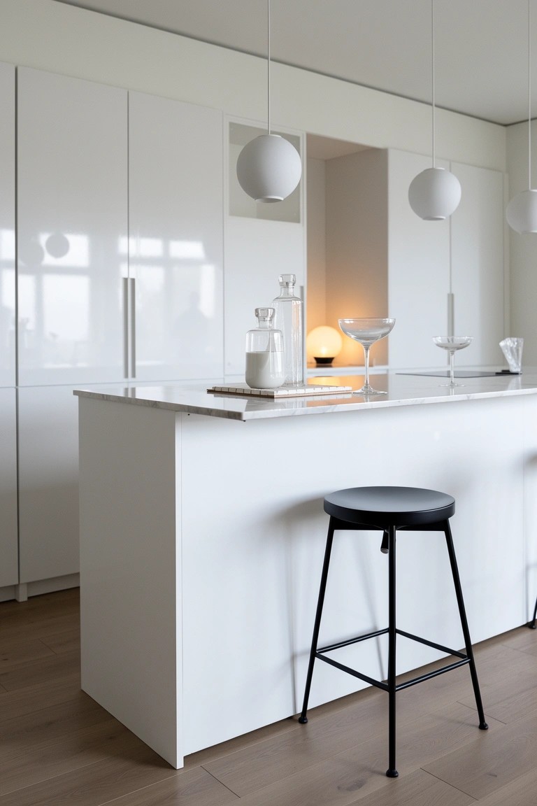 White kitchen island bar with black stool, pendant lights, and minimal decor
