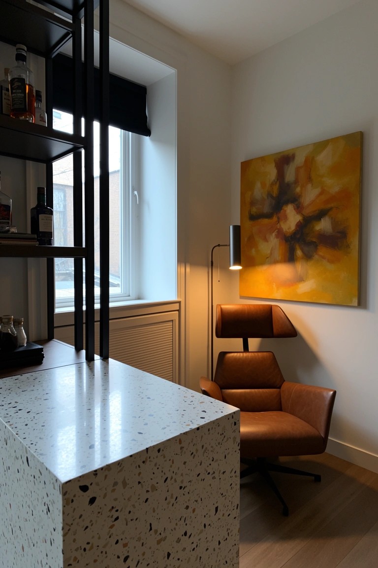 Black metal open shelving with whiskey bottles above white terrazzo bar counter in cozy room corner, leather armchair and yellow abstract wall art nearby