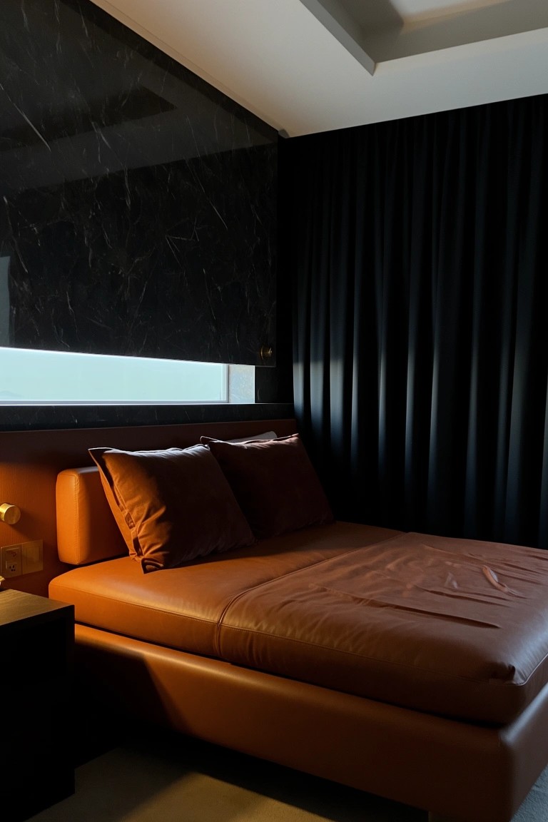 Orange leather bed in a modern bedroom with black marble walls and heavy black curtains