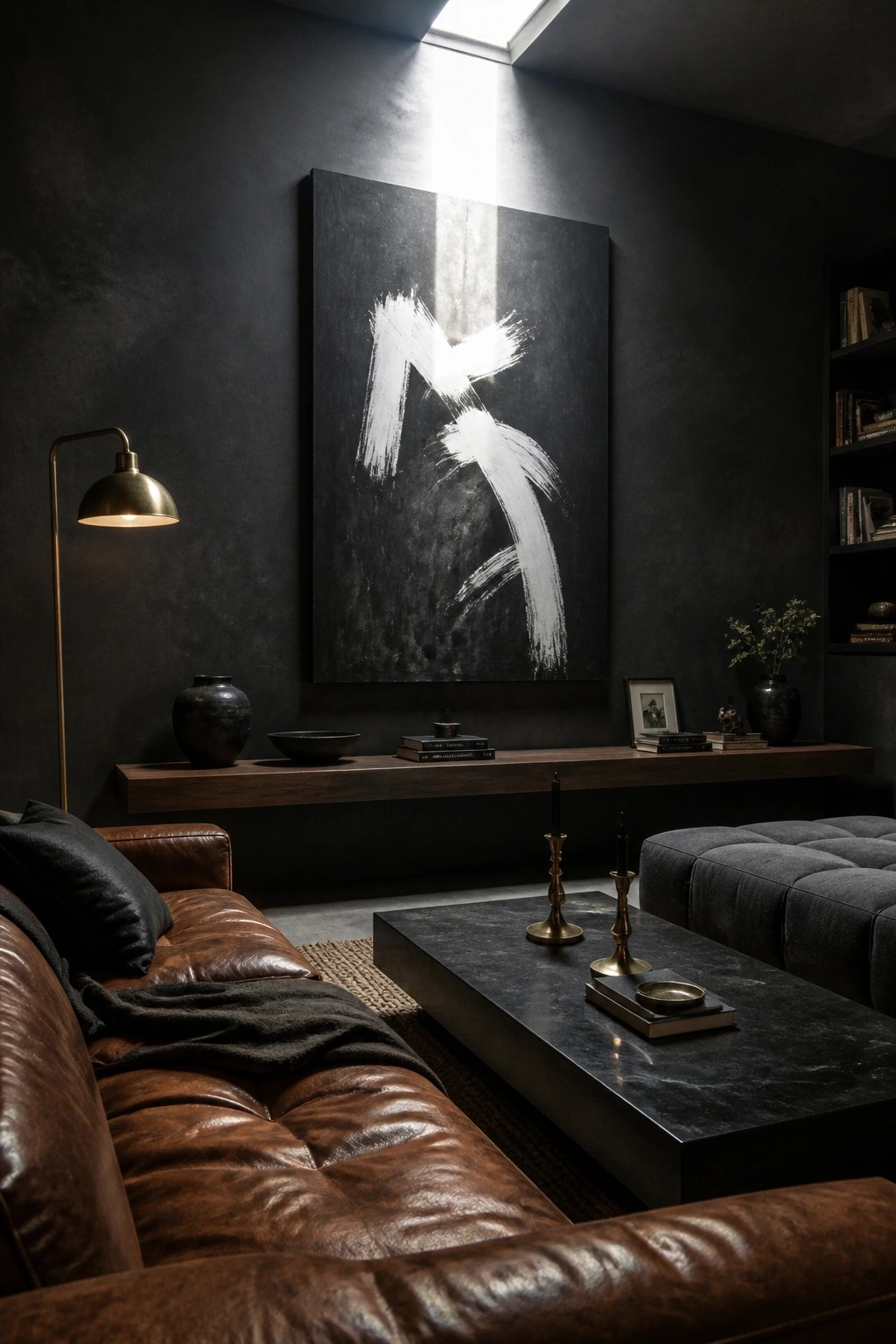 A dark living room featuring a brown leather sofa, a large abstract black and white painting on the wall, a wooden floating shelf, and a black marble coffee table.