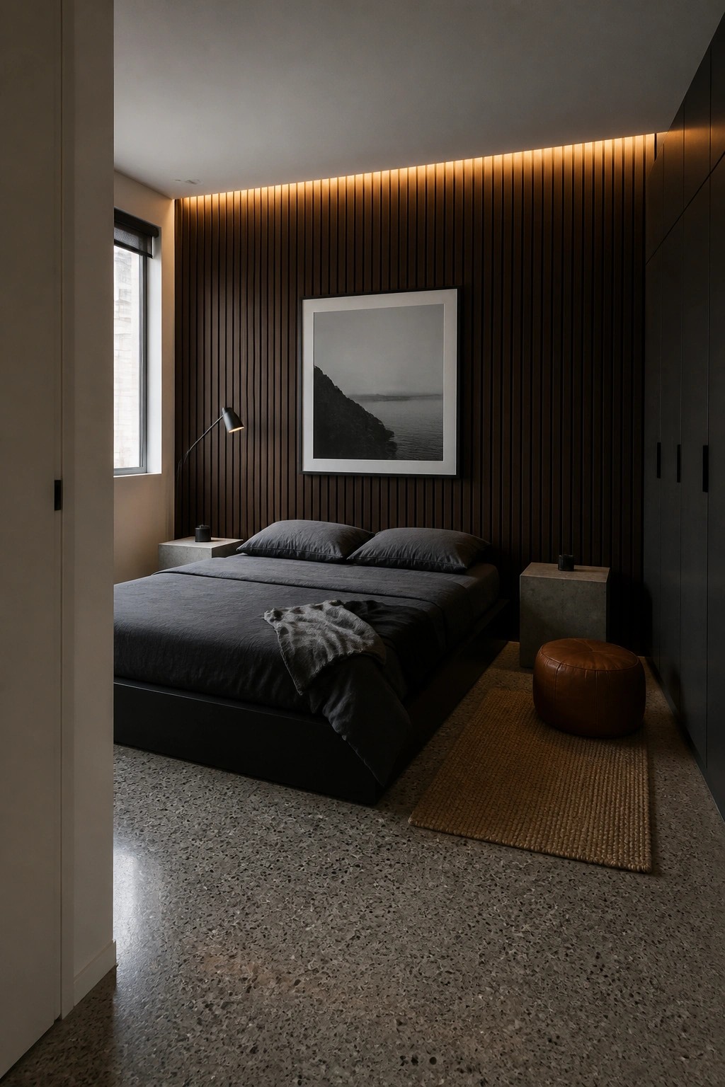 A modern bedroom with a low platform bed dressed in dark gray bedding, positioned in front of a dark brown vertical slatted wood accent wall that features a large framed black and white landscape photograph centered above the headboard.