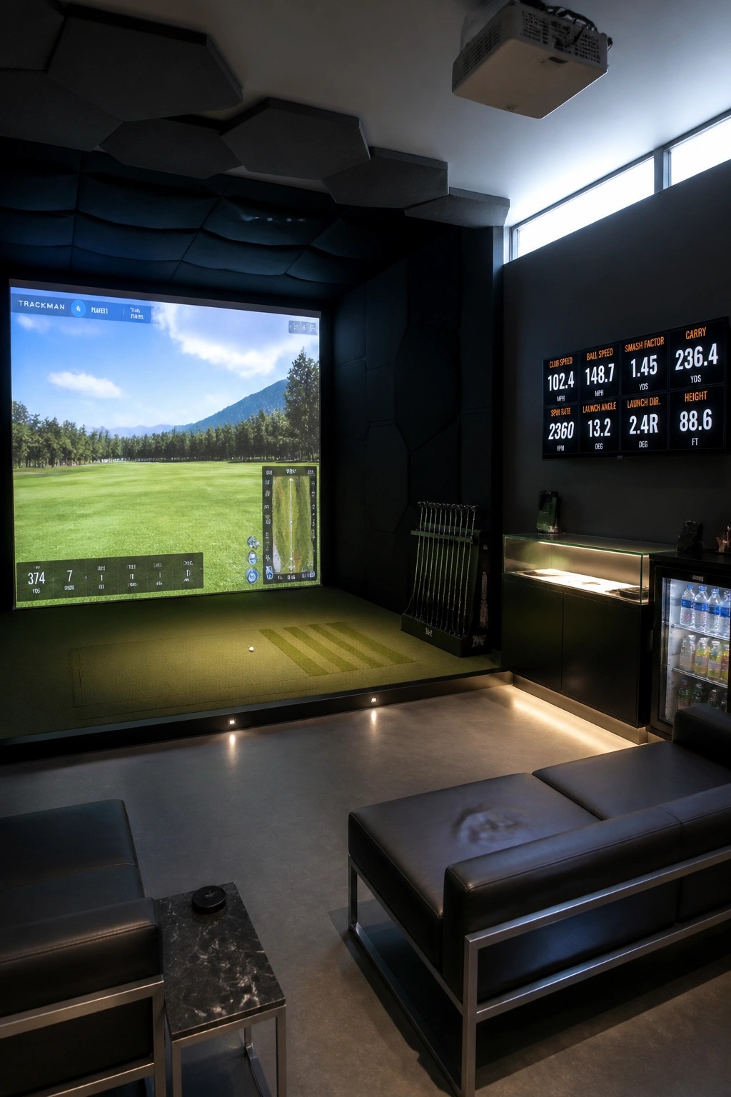 Modern indoor golf simulator with large course screen, stats display, clubs, and black seating.