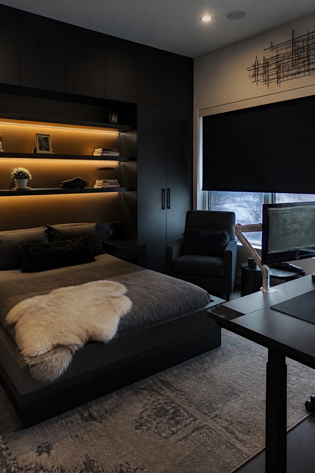 A modern bedroom with a dark wood bed, built-in black cabinetry and backlit shelves, a desk with monitor, and a gray area rug.