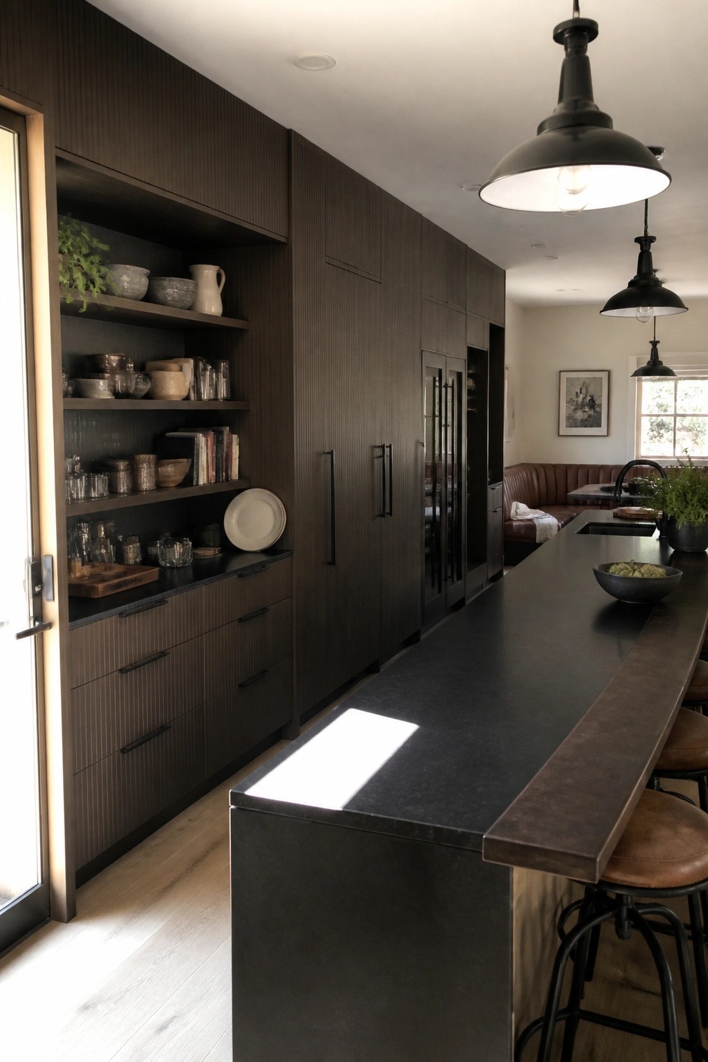 Modern kitchen with dark wood cabinets, black stone island, and pendant lights