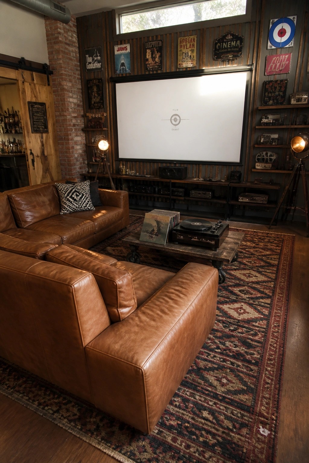 A living room with brown leather couches, a large projector screen, a record player on a wooden table, and multiple vintage signs mounted on dark wood-paneled walls.