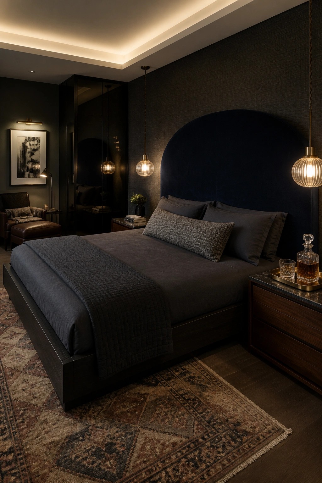 Dark modern bedroom with large bed, navy headboard, pendant lights, and patterned rug