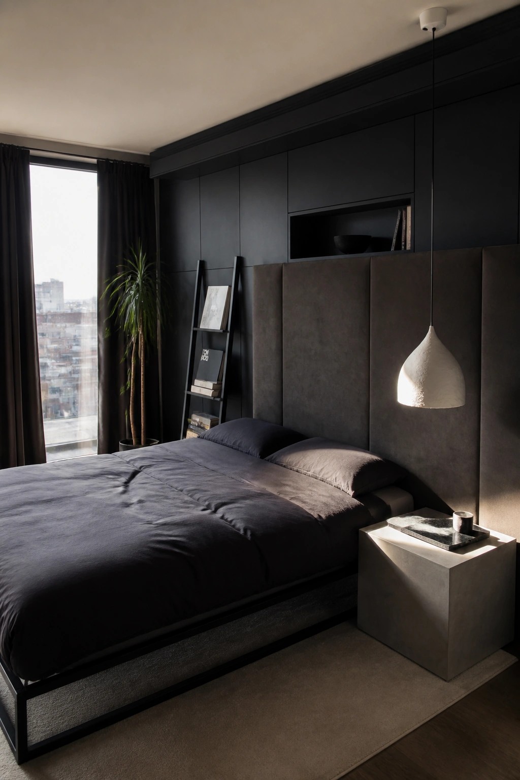 Modern dark bedroom with gray bed, black headboard, concrete nightstand, and pendant light.