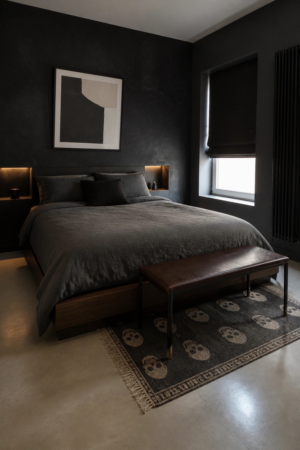 A dark masculine bedroom with black walls, a large bed with dark gray bedding, recessed lit niches beside the headboard, and a brown leather bench on a patterned rug.