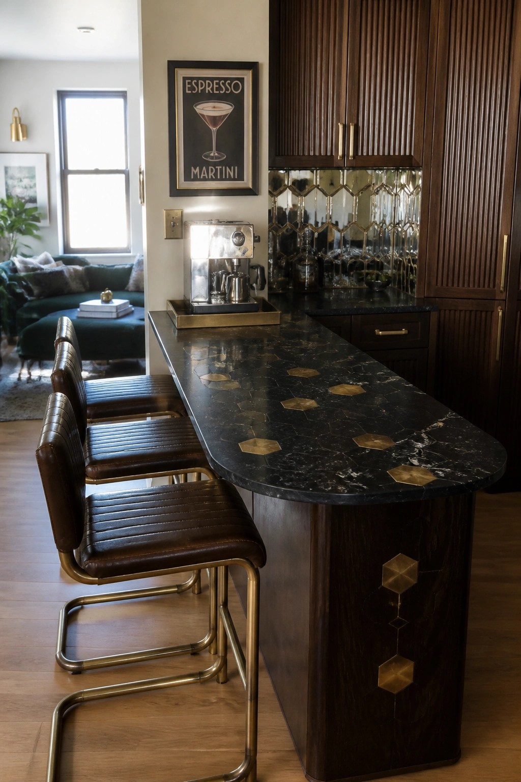 A kitchen bar area with a black marble countertop featuring gold hexagonal inlays, three brown leather and brass stools, dark wood cabinetry, and an espresso machine on the counter.