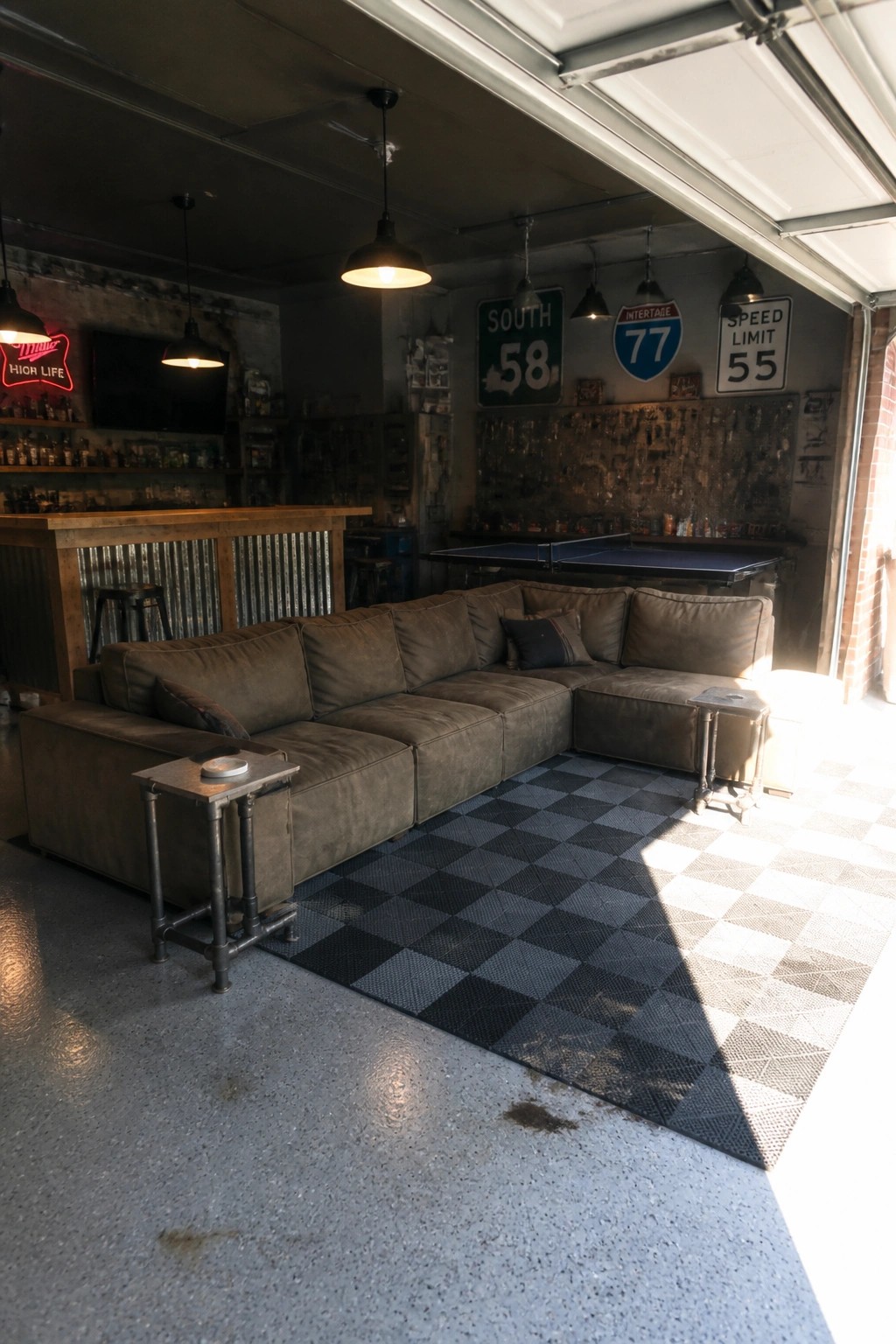 Industrial lounge with brown sectional sofa on checkered rug, road signs, and bar area