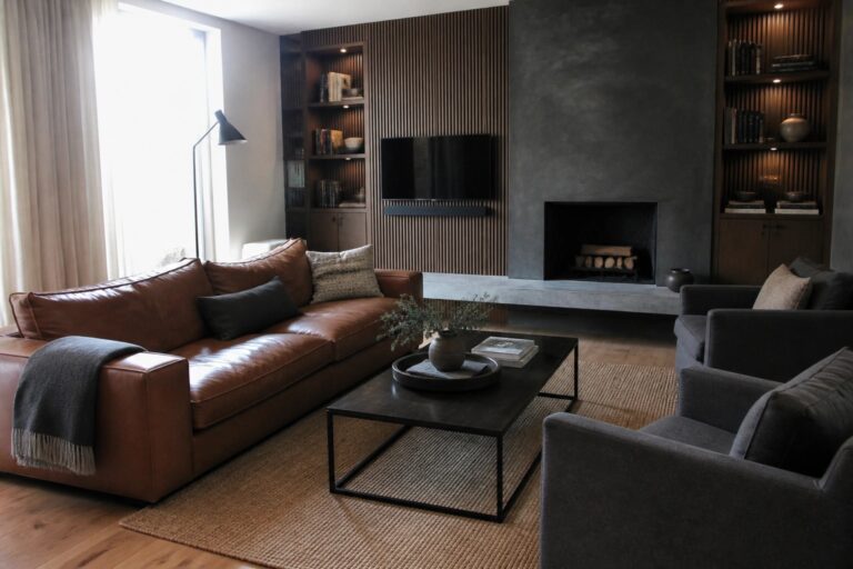24 Contemporary Masculine Interior Design Ideas With Fluted Wood and Textured Walls A living room with a central fireplace, concrete mantel, wall-mounted television, and vertical wood slat paneling flanked by built-in bookshelves.