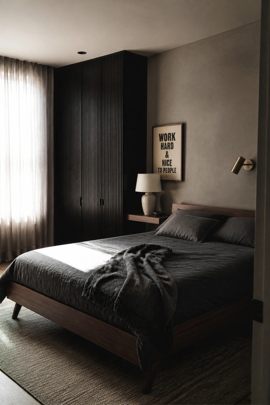 A contemporary bedroom with a large fluted dark wood wardrobe, wooden bed with dark gray linens, a wall-mounted lamp, and a motivational poster on a textured gray wall.