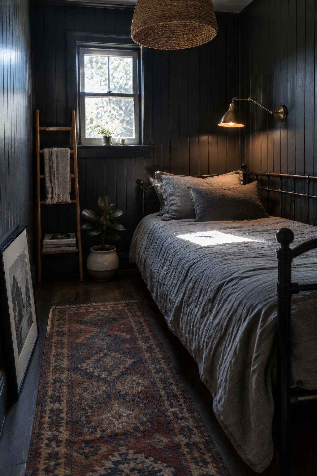 A small bedroom with charcoal vertical paneling, gray bedding, a black metal bed frame, and a window.