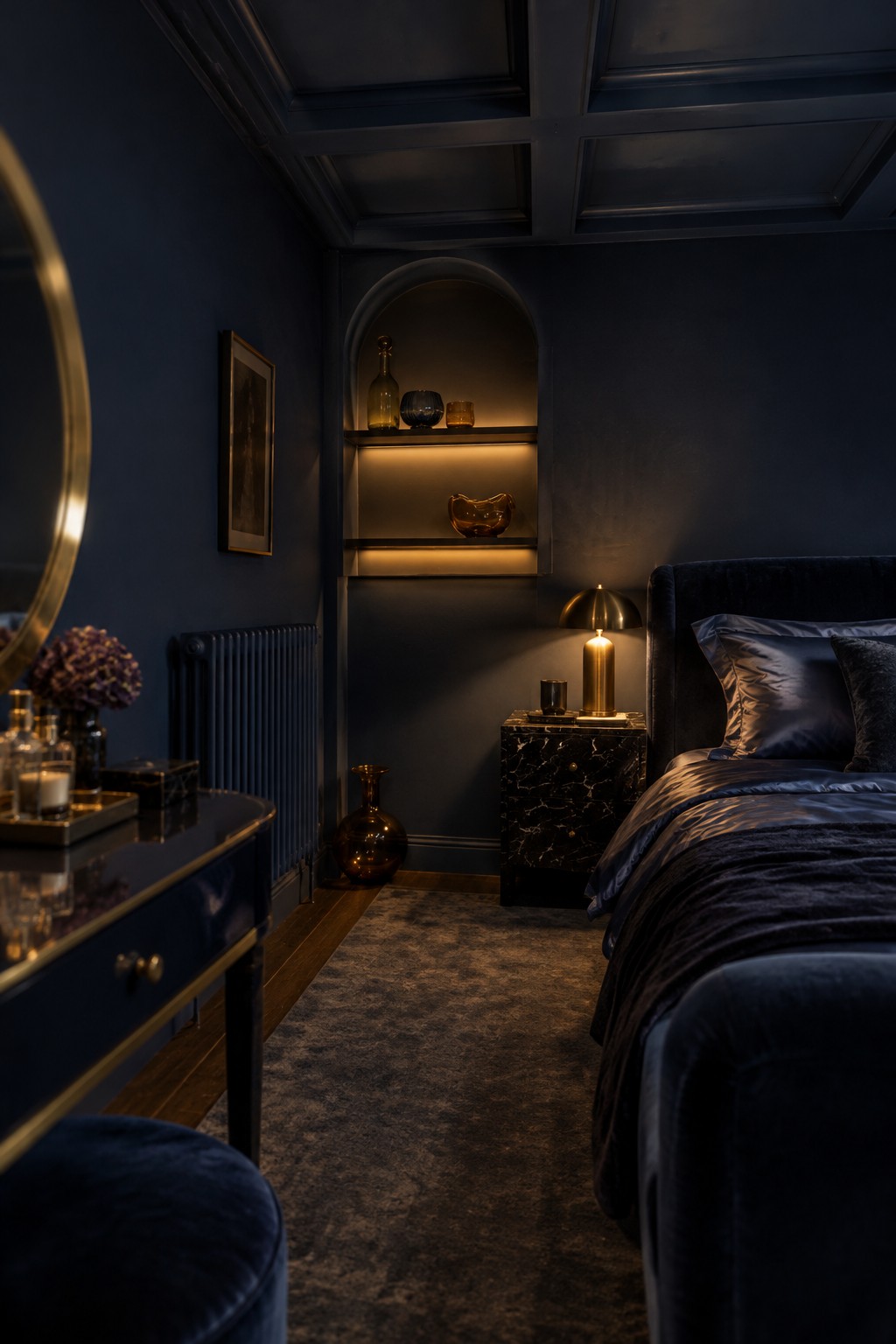 A dark bedroom with an arched recessed shelving niche, a bed, and a narrow rug.