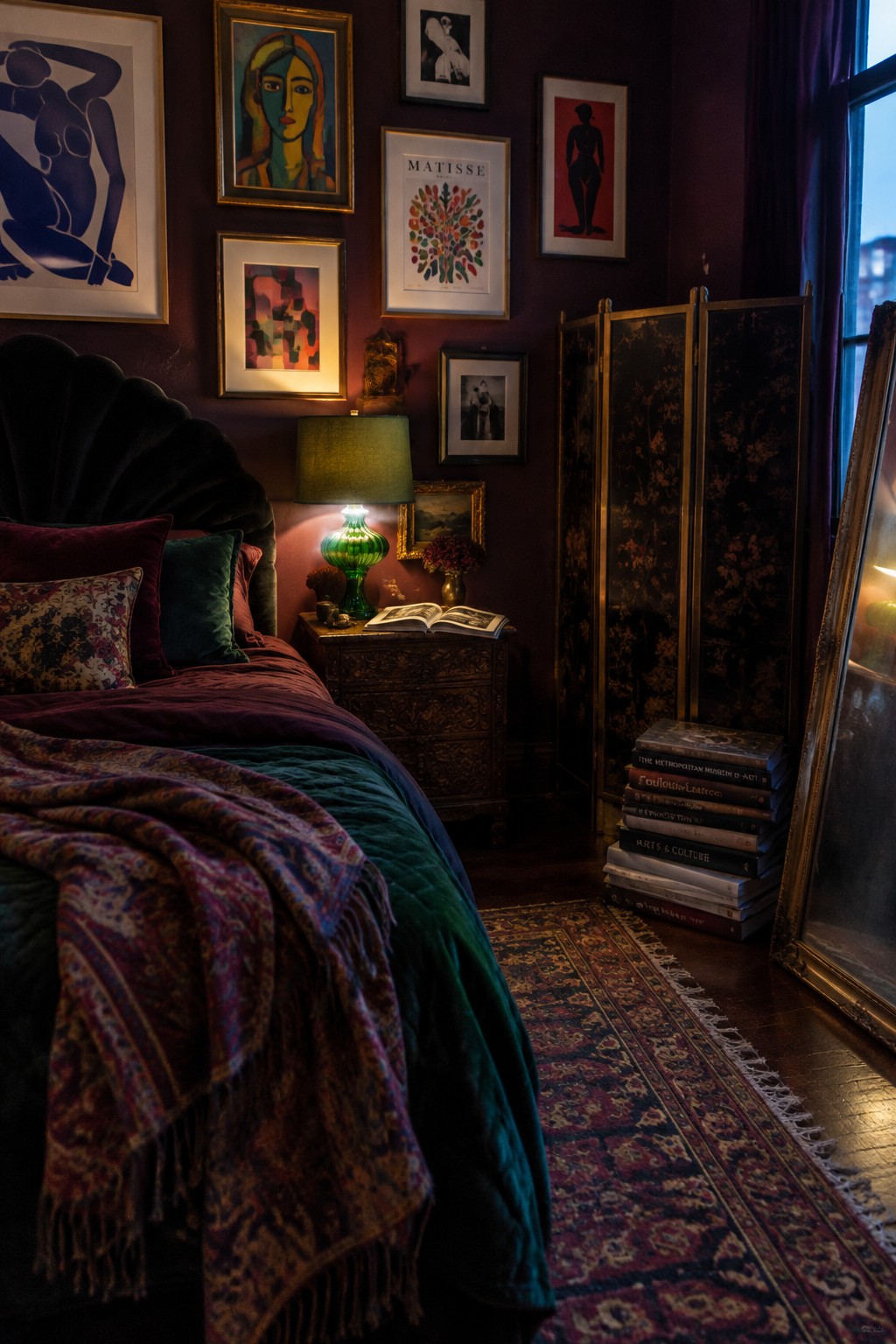 A dark bedroom with a gallery wall of colorful and black-and-white framed art above a bed.